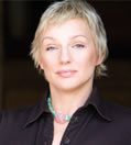 A woman with short blonde hair wearing a black shirt.