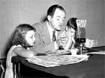 A man and two girls sitting at a table.