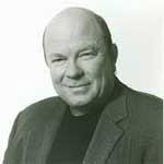 A man with a bald head and wearing a jacket.
