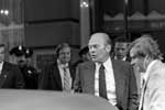 A man in suit and tie standing next to another man.