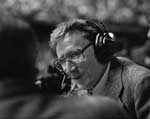 A man with headphones on and glasses