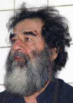 A man with long hair and beard is looking at the camera.