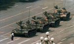 A group of tanks are driving down the street.