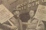 Two men holding signs in front of a building.